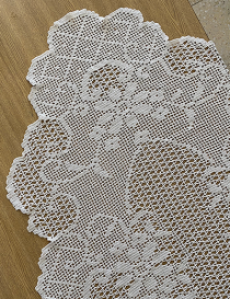 Close-up of floral lace patterns on white wood background