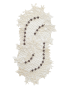Overhead view of an elongated white lace table runner with floral accents on a white background.