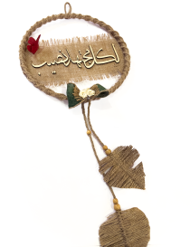 Full view of rustic Arabic wall hanging with jute leaf tassels.