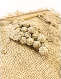 Closeup to burlap wall hanger with 3D twine grape cluster and three hooks.