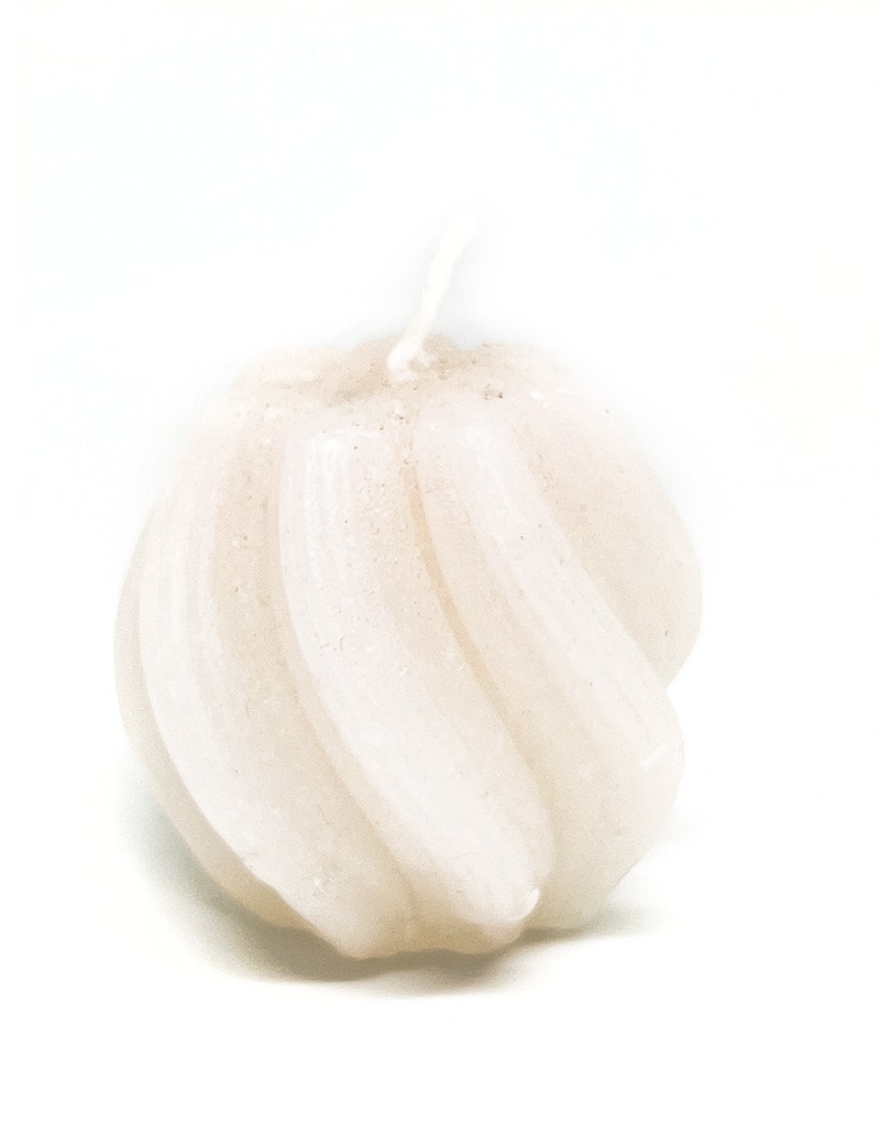Cream colored twisted sphere candle with ribbed texture on white background.