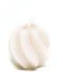 Cream colored twisted sphere candle with ribbed texture on white background.