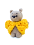 Miniature handmade beige crochet teddy bear wearing a bright yellow textured sweater.