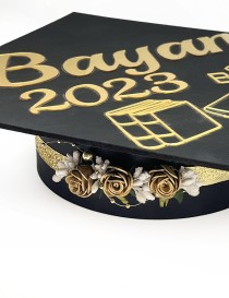 Golden fabric rose wreath accessory with white berries on a gold ribbon In use.