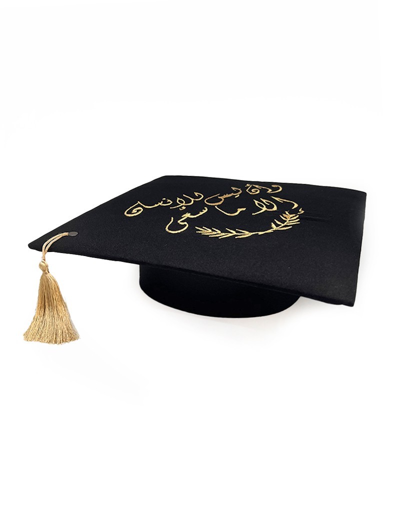 Graduation cap topper with gold Arabic calligraphy and colorful floral embroidery.