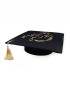 Graduation cap topper with gold Arabic calligraphy and colorful floral embroidery.