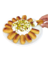 A hand dipping a golden Karabij cookie into fluffy white Natef meringue topped with crushed pistachios.