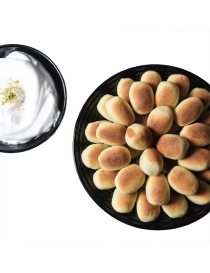 Platter of golden Walnut Karabij cookies with a bowl of white Natef meringue dip.