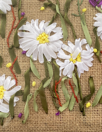 Macro view of the intricate satin ribbon stitching and burlap texture.